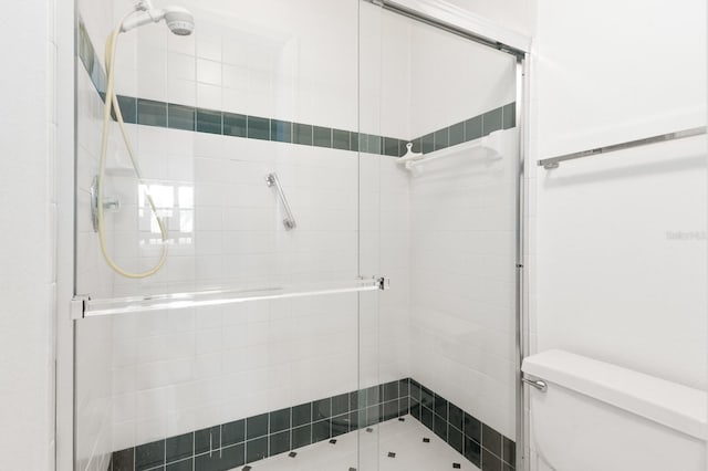 bathroom with toilet and a shower with shower door