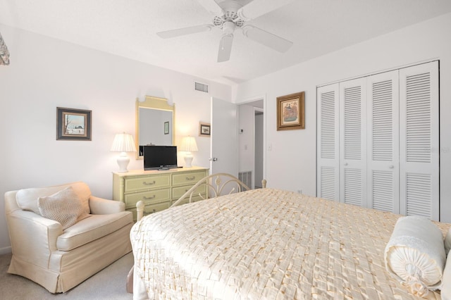 bedroom with ceiling fan, light carpet, and a closet