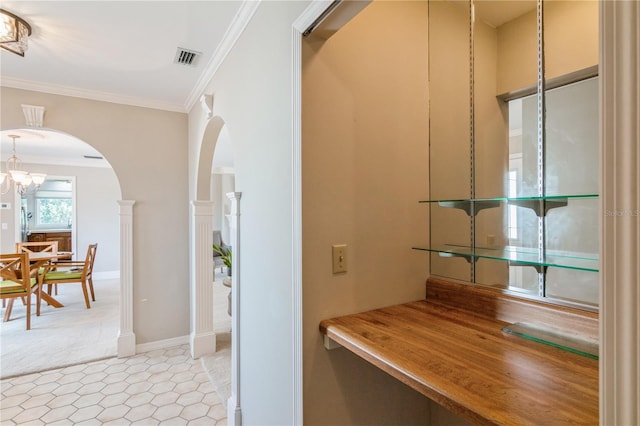 hallway featuring a chandelier and crown molding