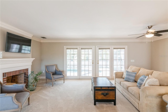 carpeted living room with a fireplace, ceiling fan, and crown molding