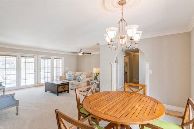 carpeted dining area featuring crown molding and ceiling fan with notable chandelier