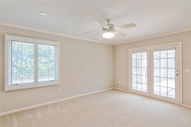 unfurnished room with plenty of natural light, ceiling fan, light colored carpet, and crown molding