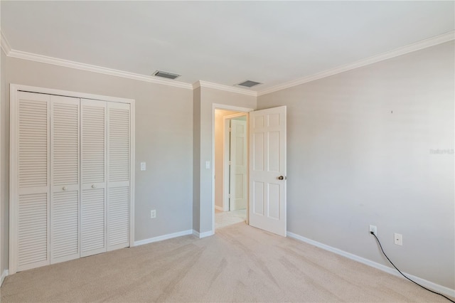 unfurnished bedroom featuring crown molding, light carpet, and a closet