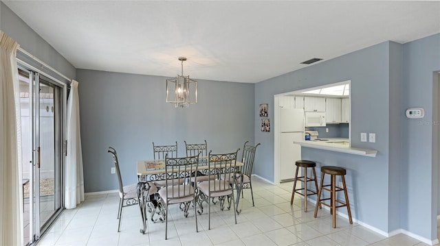 dining area with light tile patterned floors and a notable chandelier