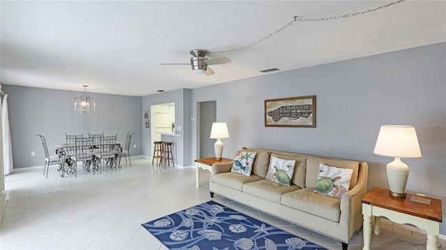 living room featuring light tile patterned floors and ceiling fan with notable chandelier