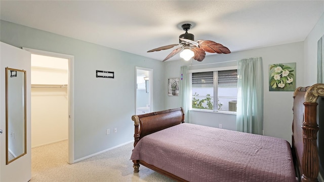 bedroom with ceiling fan, ensuite bath, a spacious closet, and a closet