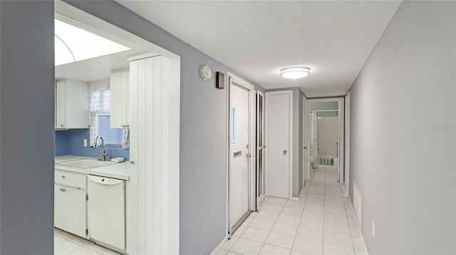 hallway with light tile patterned flooring and sink