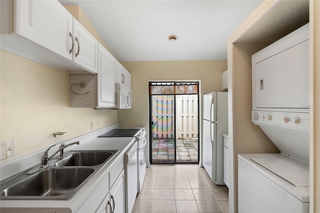 kitchen featuring white cabinetry, white appliances, sink, and stacked washer and clothes dryer