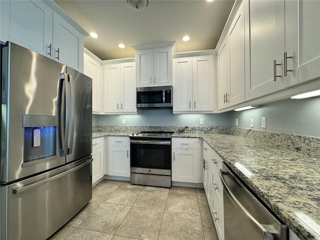 kitchen with light stone countertops, white cabinetry, and stainless steel appliances