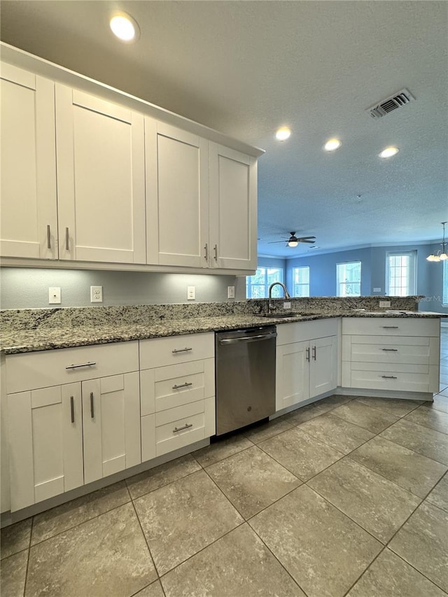 kitchen featuring a wealth of natural light, ceiling fan, white cabinets, and stainless steel dishwasher