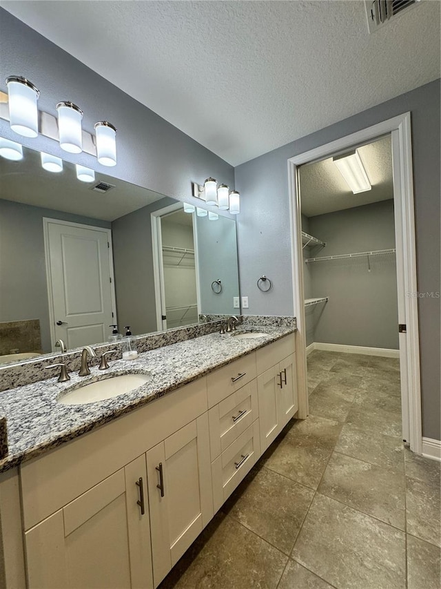 bathroom featuring a textured ceiling and vanity