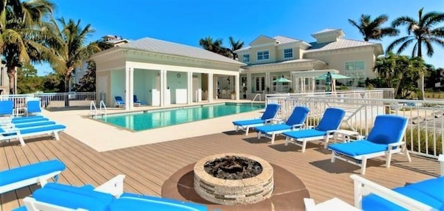 view of swimming pool featuring a patio area, a deck, and an outdoor fire pit