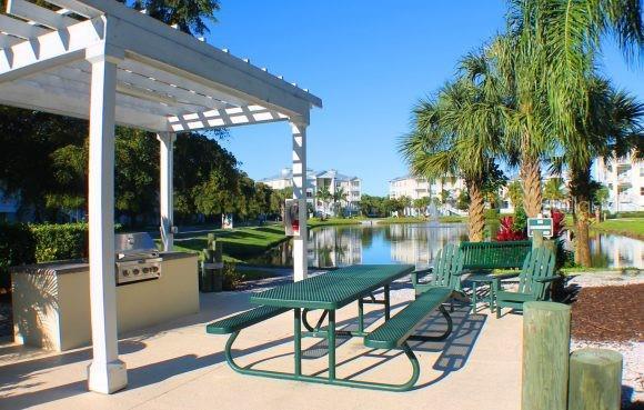 surrounding community featuring an outdoor kitchen, a water view, and a pergola