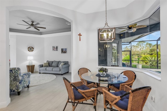 dining area featuring ceiling fan with notable chandelier and light hardwood / wood-style flooring