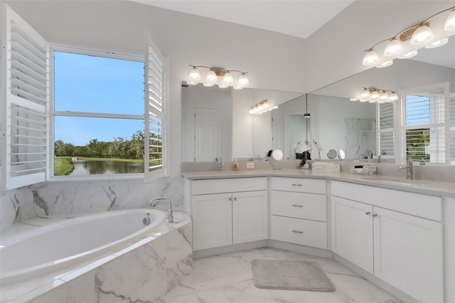 bathroom with tiled bath, vanity, and a water view