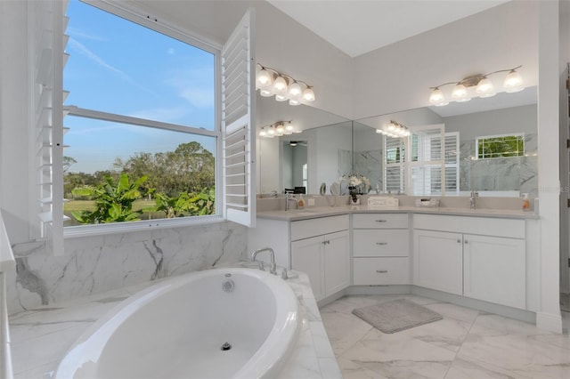 bathroom with vanity, a wealth of natural light, and tiled tub