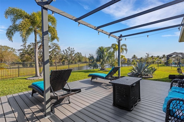 wooden deck with a water view, a pergola, and a yard