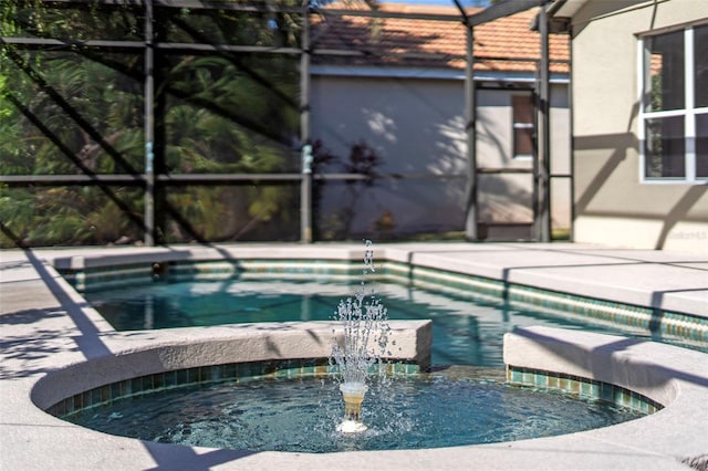 view of pool with pool water feature, a lanai, and an in ground hot tub