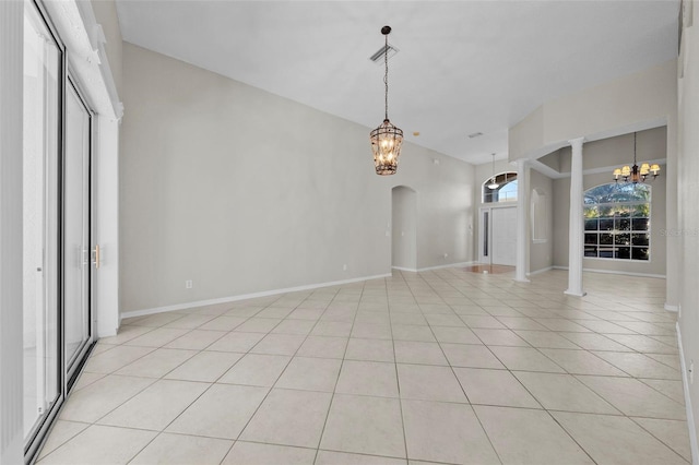 interior space with light tile patterned flooring, ornate columns, and a chandelier