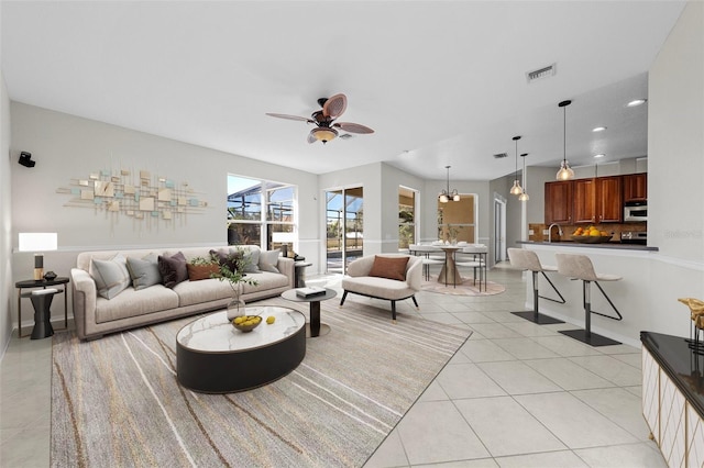 living room with light tile patterned floors and ceiling fan with notable chandelier