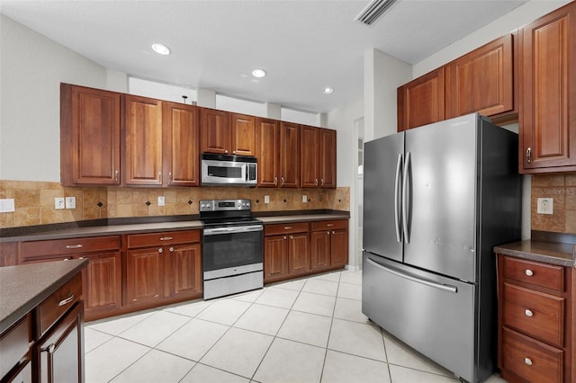 kitchen with decorative backsplash, light tile patterned flooring, and stainless steel appliances