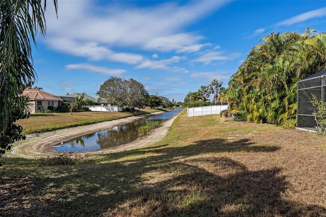 view of yard featuring a water view and glass enclosure