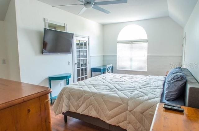 bedroom featuring hardwood / wood-style floors, ceiling fan, and lofted ceiling