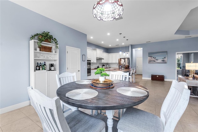 tiled dining room featuring an inviting chandelier and sink