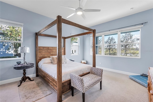 carpeted bedroom with multiple windows and ceiling fan