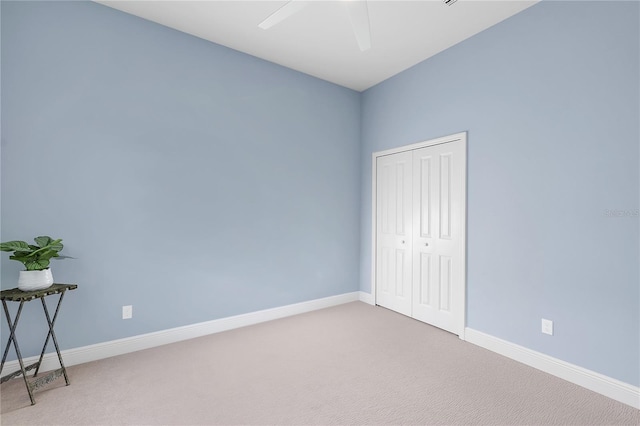 unfurnished bedroom featuring ceiling fan, a closet, and carpet floors