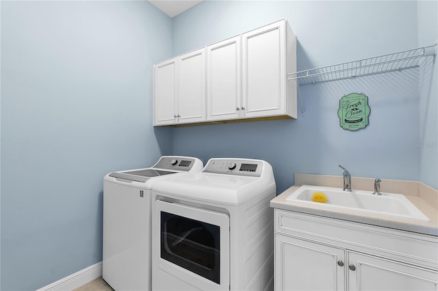 washroom with cabinets, washer and clothes dryer, and sink