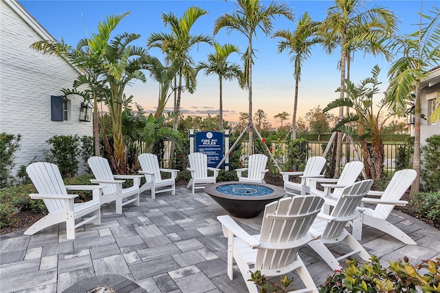 patio terrace at dusk featuring an outdoor fire pit