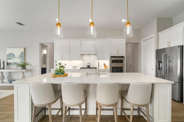 kitchen with white cabinets, a large island, and stainless steel appliances