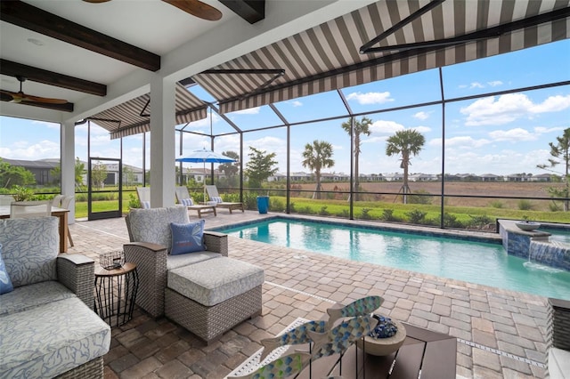 view of swimming pool with an in ground hot tub, pool water feature, ceiling fan, glass enclosure, and a patio area