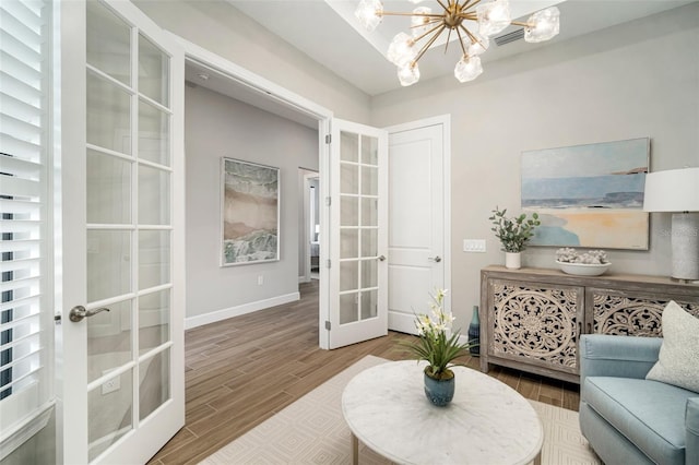 sitting room with french doors and an inviting chandelier