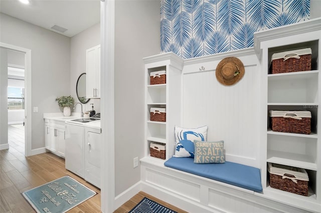 mudroom with separate washer and dryer and light hardwood / wood-style flooring