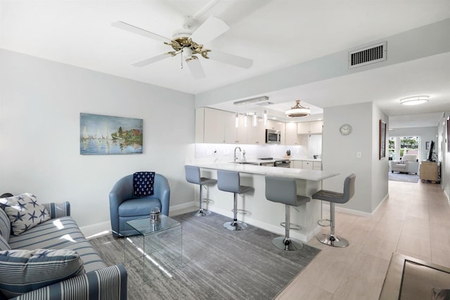 living room with ceiling fan and sink