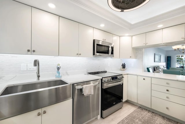 kitchen with white cabinets, sink, light tile patterned floors, stainless steel appliances, and a chandelier