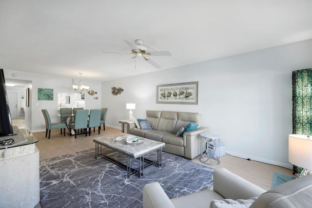 living room with dark hardwood / wood-style floors and ceiling fan with notable chandelier