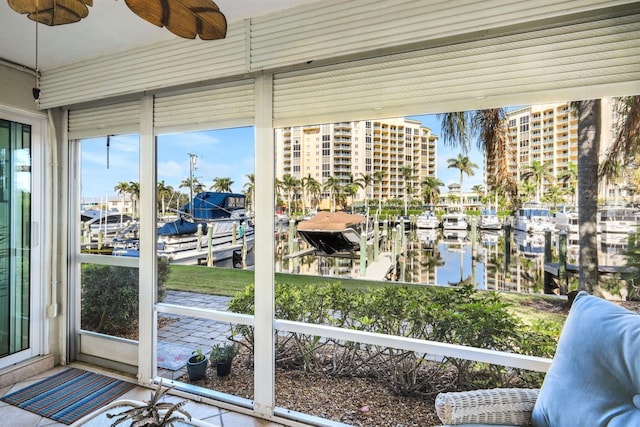 unfurnished sunroom with ceiling fan and a water view