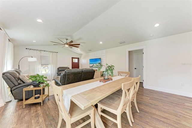 dining space with hardwood / wood-style floors, ceiling fan, and lofted ceiling