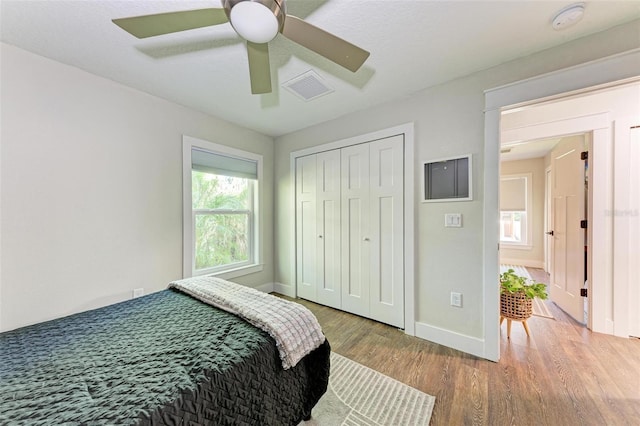 bedroom with wood-type flooring, a closet, and ceiling fan