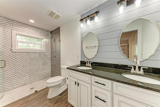 bathroom with vanity, toilet, a textured ceiling, an enclosed shower, and wood-type flooring