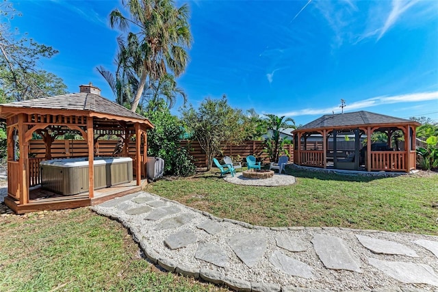 view of yard featuring a gazebo, a hot tub, and a fire pit