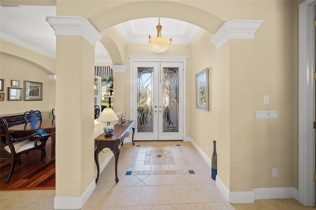 tiled foyer with a chandelier, decorative columns, ornamental molding, and french doors