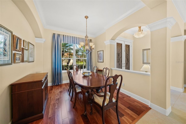 dining area featuring ornamental molding, a notable chandelier, and wood-type flooring