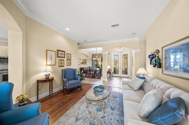 living room featuring crown molding, french doors, a chandelier, and wood-type flooring