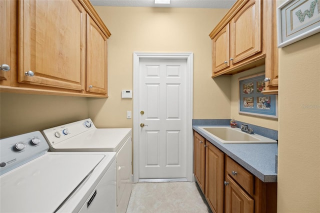 laundry room with cabinets, independent washer and dryer, sink, and light tile patterned floors