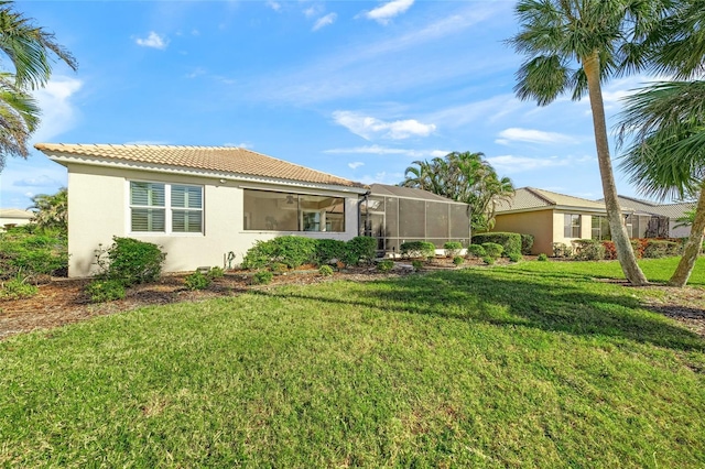 back of house with a lawn and a lanai