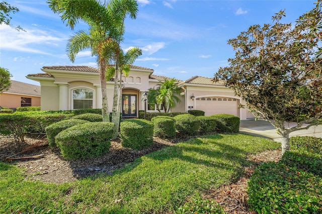 mediterranean / spanish-style house featuring a garage and a front yard